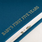 Close-up of the linen cover, the gold foil and the thick pages of the CheriBOO Baby Memory Book in Deep Sea Blue