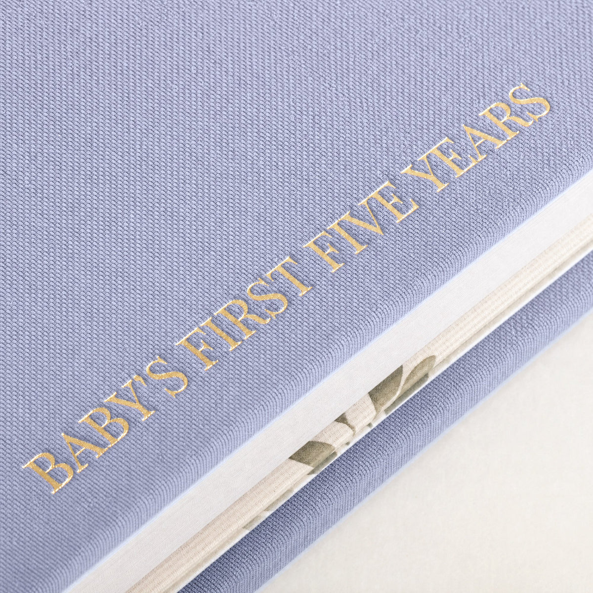 Close-up of the linen cover, the gold foil and the thick pages of the CheriBOO Baby Memory Book in Lavender