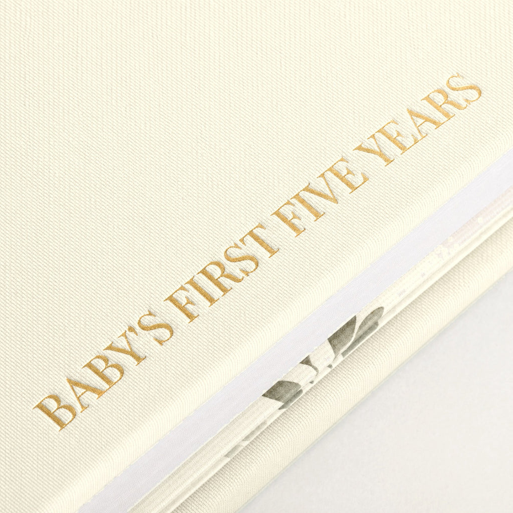 Close-up of the linen cover, the gold foil and the thick pages of the CheriBOO Baby Memory Book in Natural