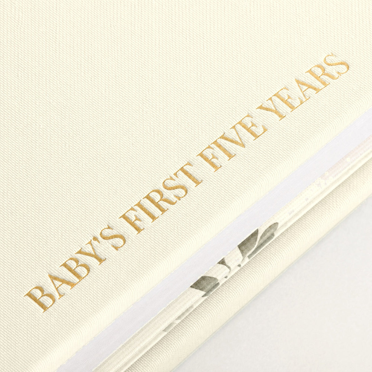 Close-up of the linen cover, the gold foil and the thick pages of the CheriBOO Baby Memory Book in Natural