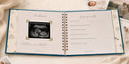 The CheriBOO Baby Memory Book in Deep Sea Blue open on the ultrasound page, with printed photos beside it
